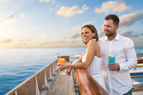 Lifestyle moment of a couple enjoying sunset views on the water, designed for travel, cruiseship and hospitality marketing.