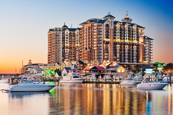 Resort exterior photographed at sunset highlighting waterfront location, marina, and evening atmosphere.