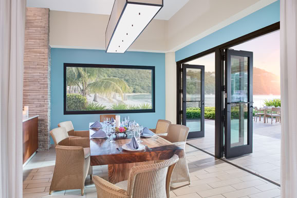 Dining space connecting interior and exterior environments, emphasizing natural light and guest experience.